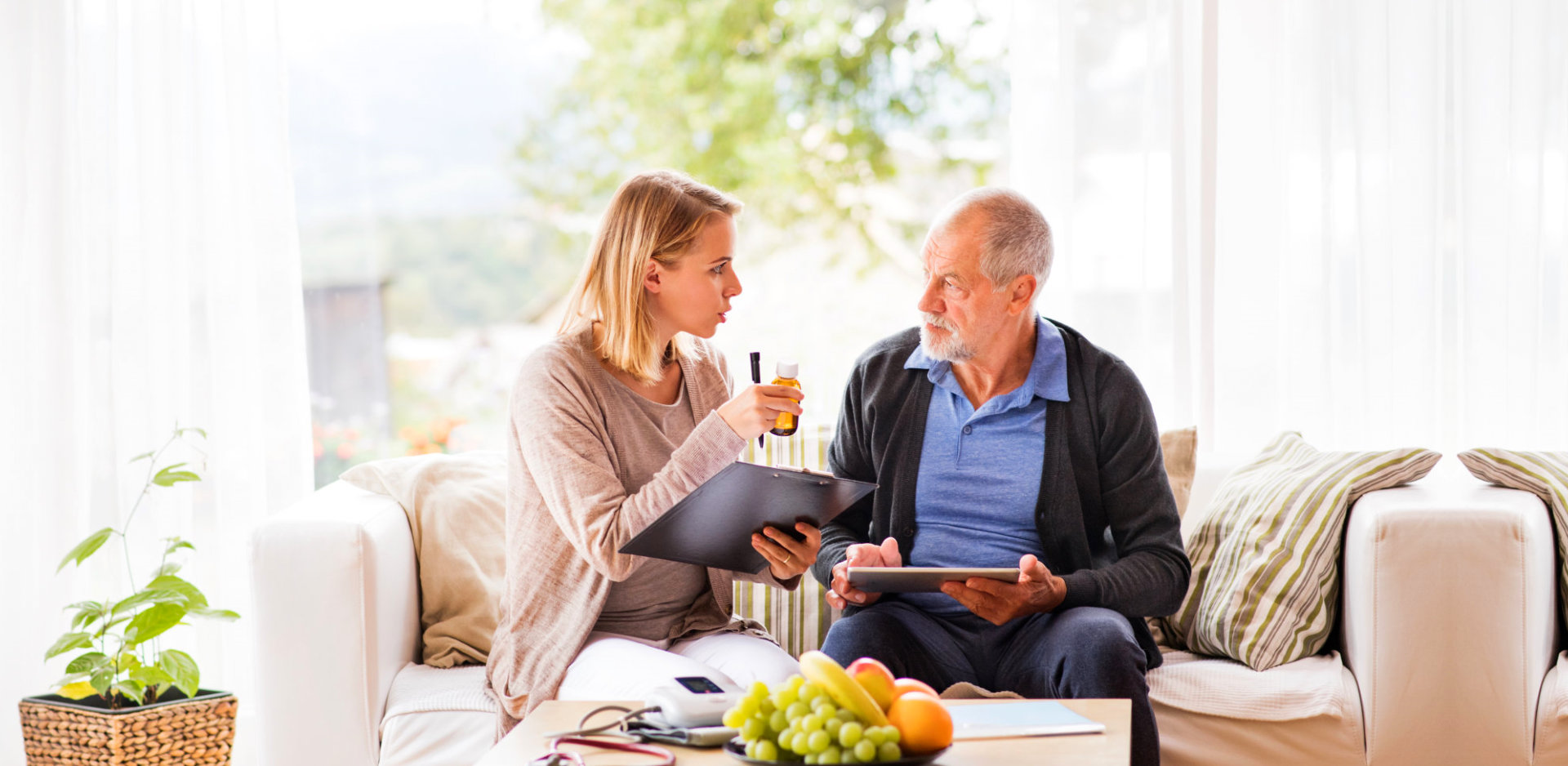 caregiver giving medicine instructions to an elderly man